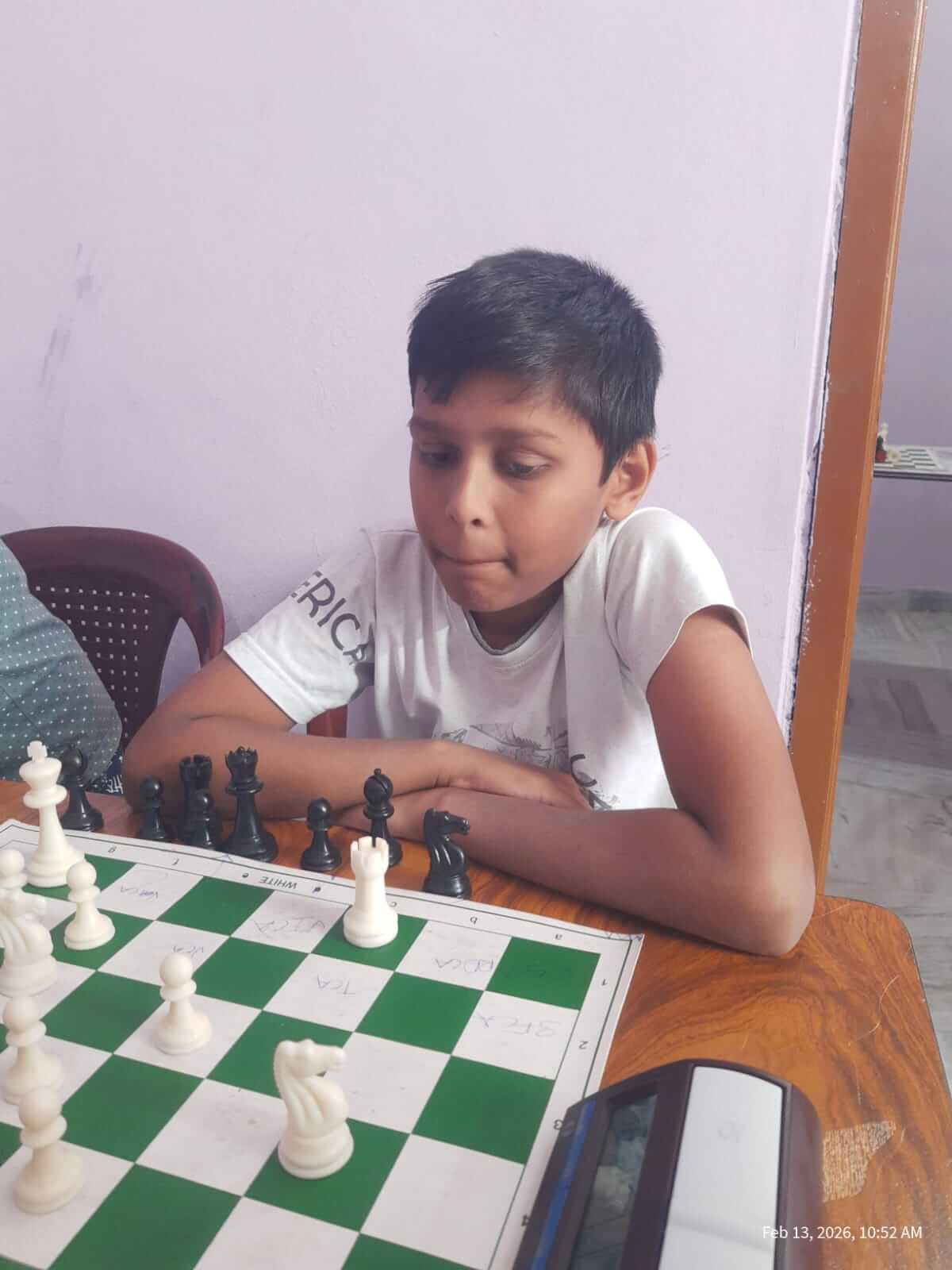 Students playing chess at wooden tables