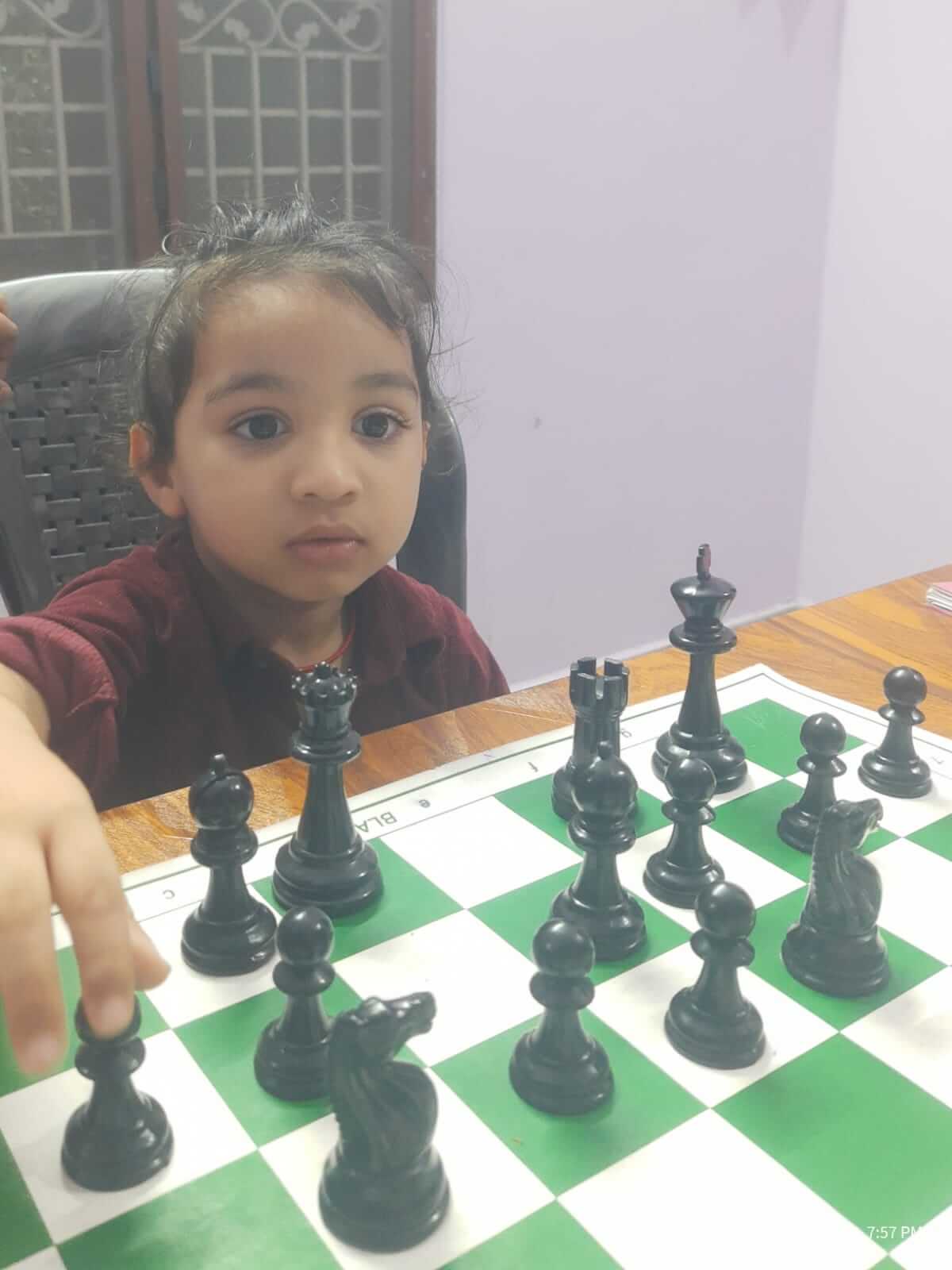 Students playing chess at wooden tables